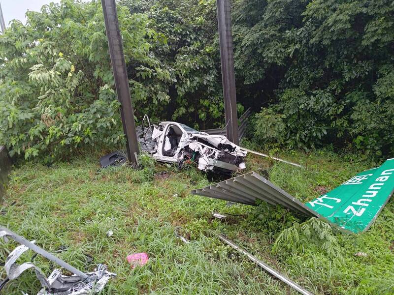 詹姓男子今早駕駛小客車經過國道1號北上99.6公里處、竹縣寶山路段，疑因天雨路滑加上操作不當，先是自撞外側護欄、再衝撞國道標誌後衝出邊坡，所幸只受輕傷。（國道二隊提供）