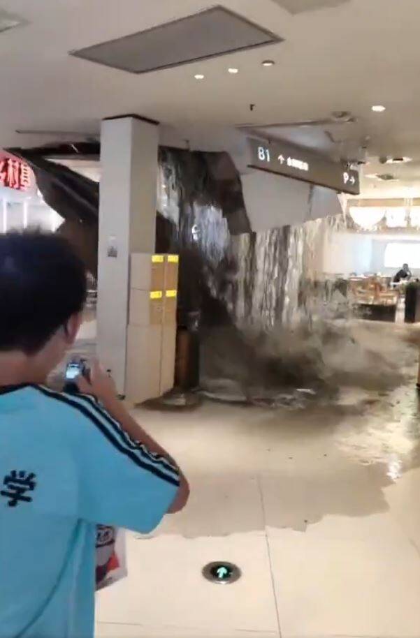 重慶一間商場因為扛不住暴雨，天花板突然垮下，大量雨水挾帶泥沙傾瀉而下，賣場中的顧客驚呼連連，四下奔逃。（擷取自微博）