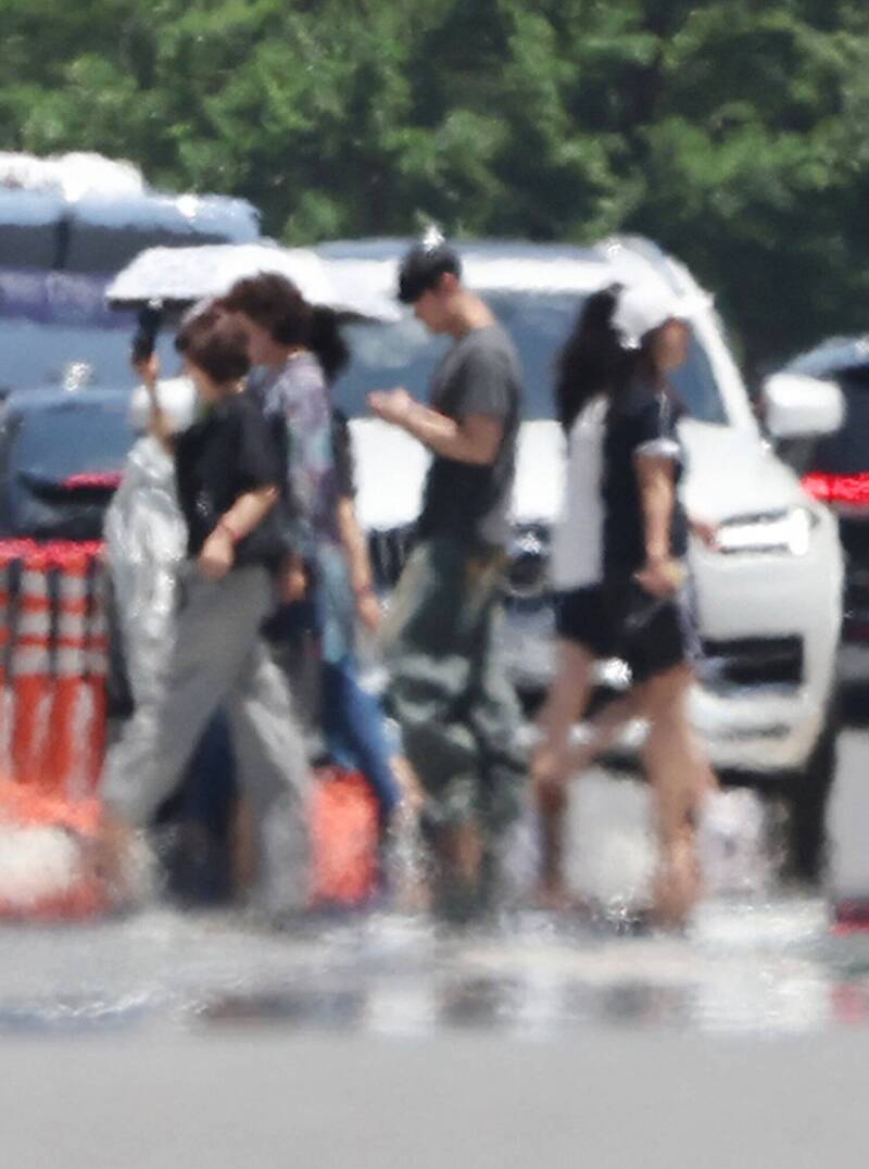 南韩局部地区近日出现高温，图为蔚山民众在热气腾腾的道路上行走。（欧新社）