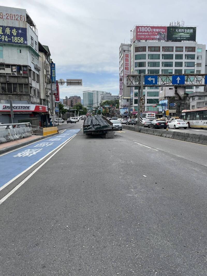 一輛載著鋼板的大型拖車在行經秀朗橋往中和方向時，拖車與前方曳引車竟突然「首尾分離」，卡在橋上。（記者鄭景議翻攝）