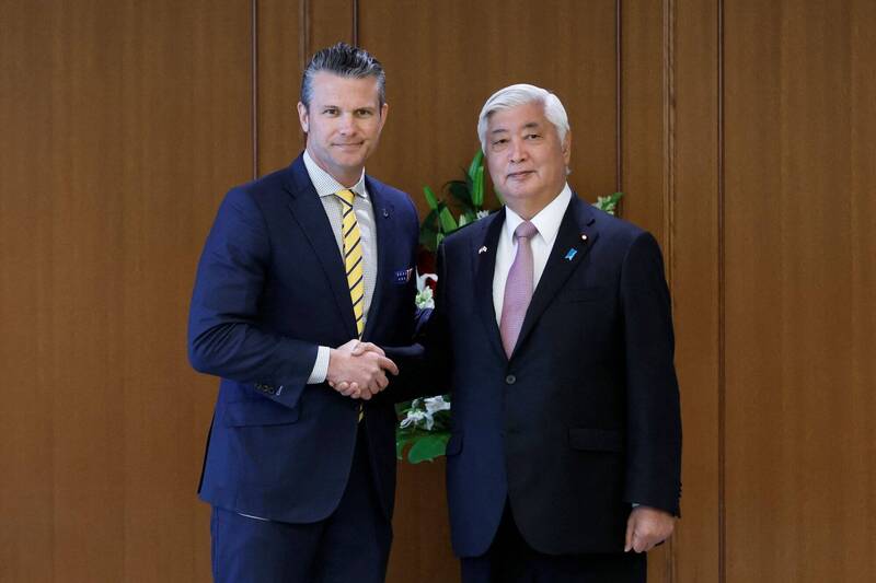 图为美国国防部长赫格塞斯（左）与日本防卫大臣中谷元（右），3月30日在东京防卫省会谈前握手合影。（路透）