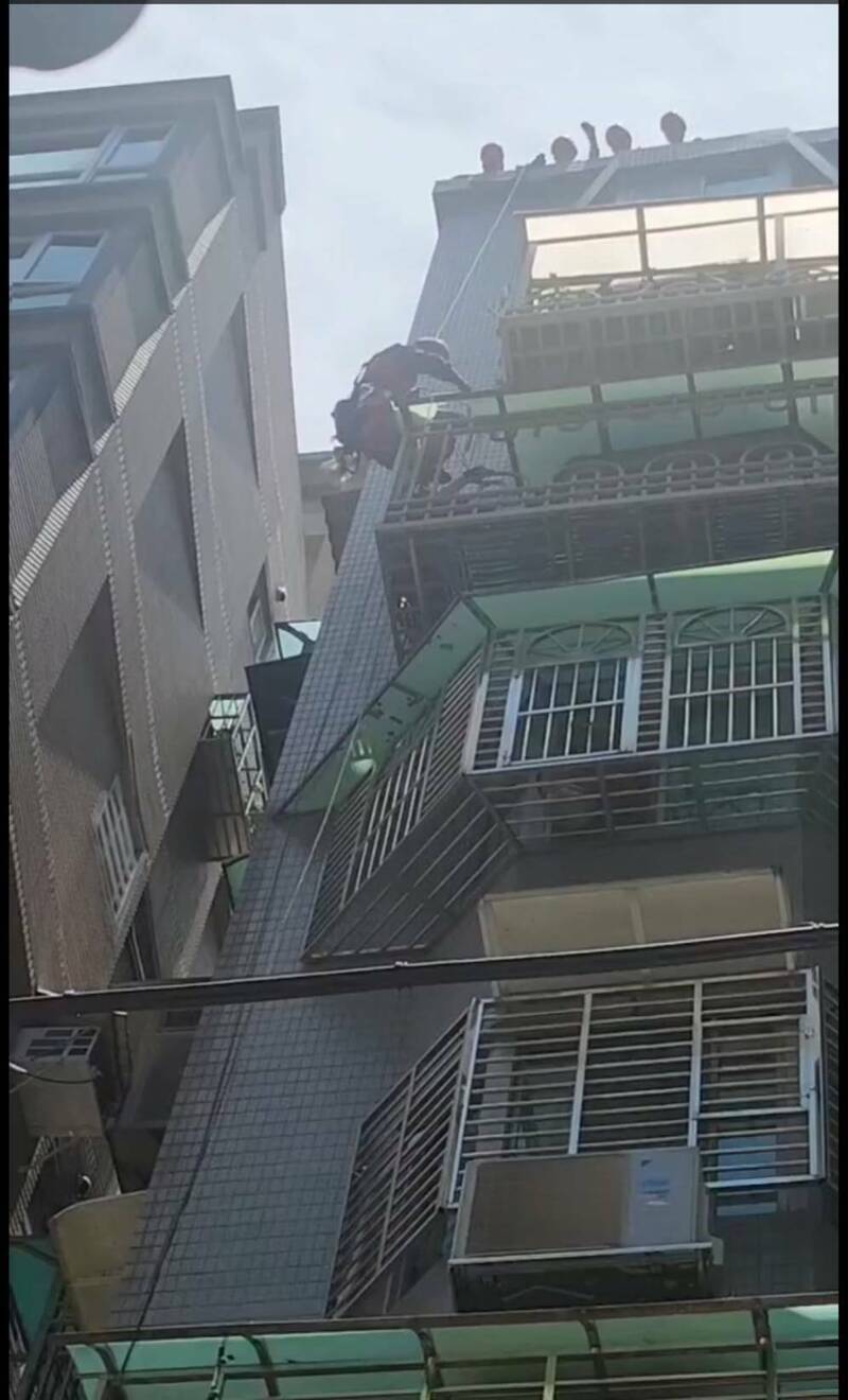 新北市淡水一名住户坠落六楼邻居阳台,消防一度尝试吊挂救人。(记者吴仁捷翻摄) 新北市淡水一名住户坠落六楼邻居阳台,消防一度尝试吊挂救人。(记者吴仁捷翻摄)