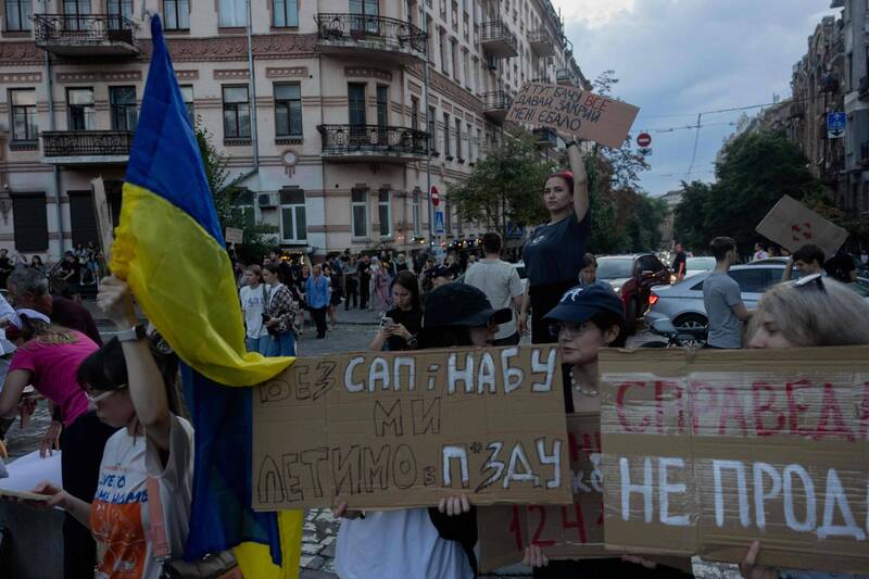 乌克兰基辅市中心7月22日傍晚，大批民众手持标语走上街头，抗议国会通过削弱反贪腐机构权限的新法案，呼吁总统泽伦斯基否决此法。（法新社）
