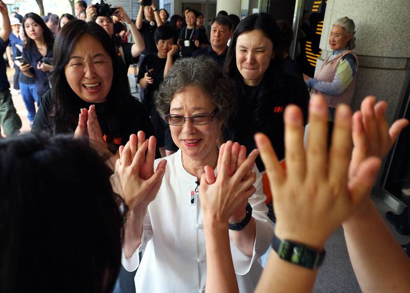 61年前因咬断性侵未遂者舌头而遭定罪的崔末子(中),23日在釜山地方法院出席重审听证会后,被支持者的掌声所包围。(法新社) 61年前因咬断性侵未遂者舌头而遭定罪的崔末子(中),23日在釜山地方法院出席重审听证会后,被支持者的掌声所包围。(法新社)