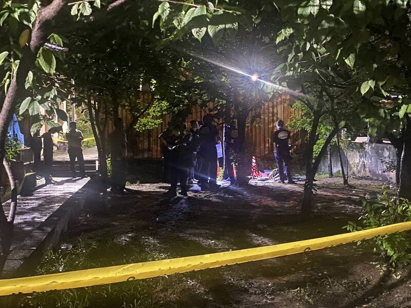 新北市新莊一處排水溝內的行李箱飄出腐臭味，驚見一具男屍被包在黑色垃圾袋中棄屍，警方封鎖現場採證。（記者徐聖倫翻攝）