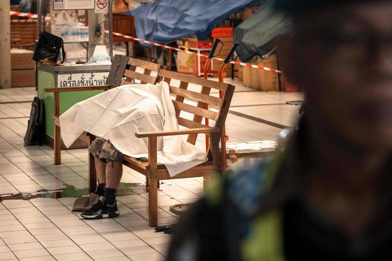 泰国61岁男子在安多哥生鲜市场枪杀多人后，在市场内的长椅上自轰。（法新社）