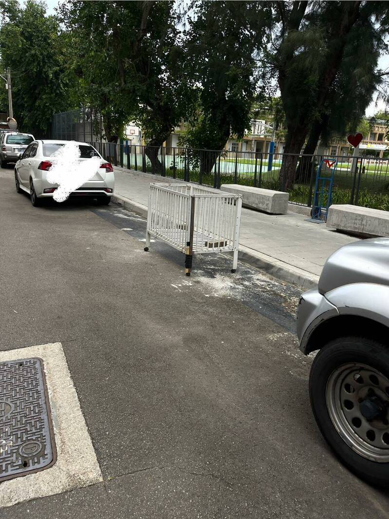新竹市东区博爱街东园国小围墙外，有人以婴儿床占地停车，遭民众爆料。（图撷取自脸书）